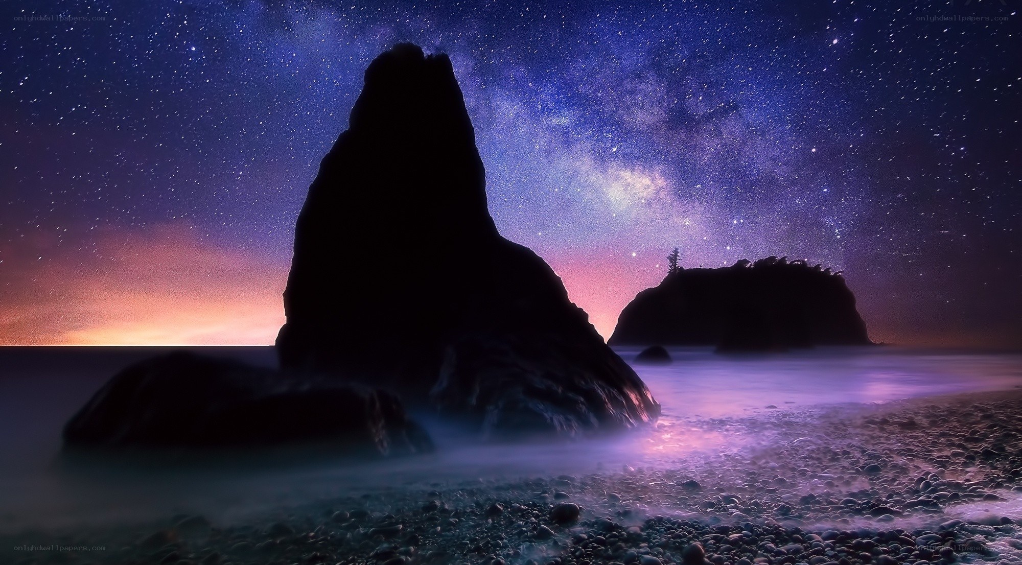 Starry night over coastal rocks