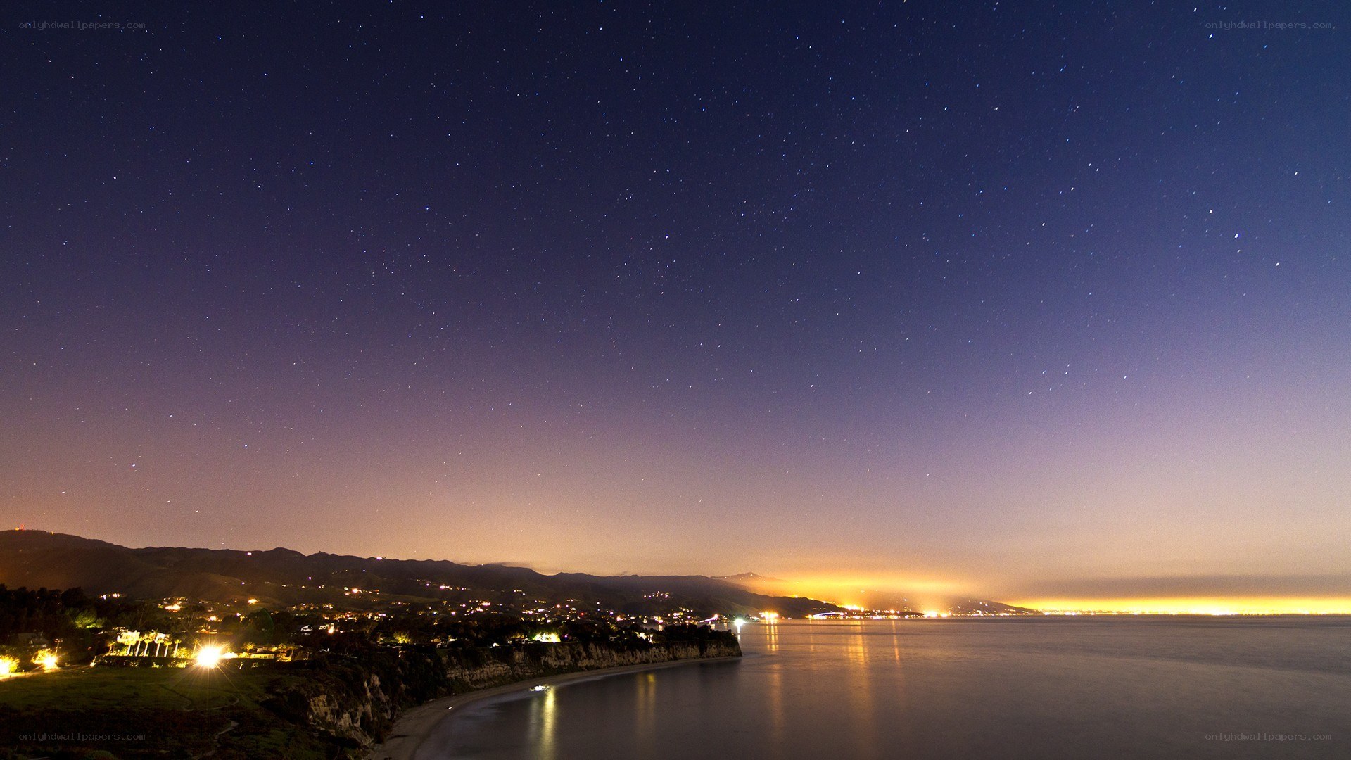 Starry night over coastal town