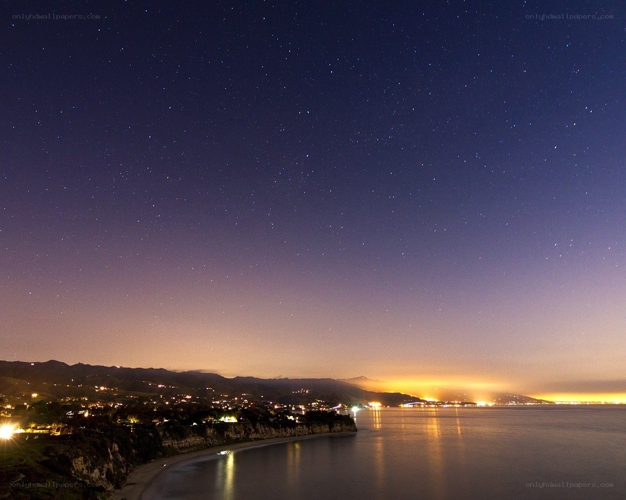 Starry night over coastal town