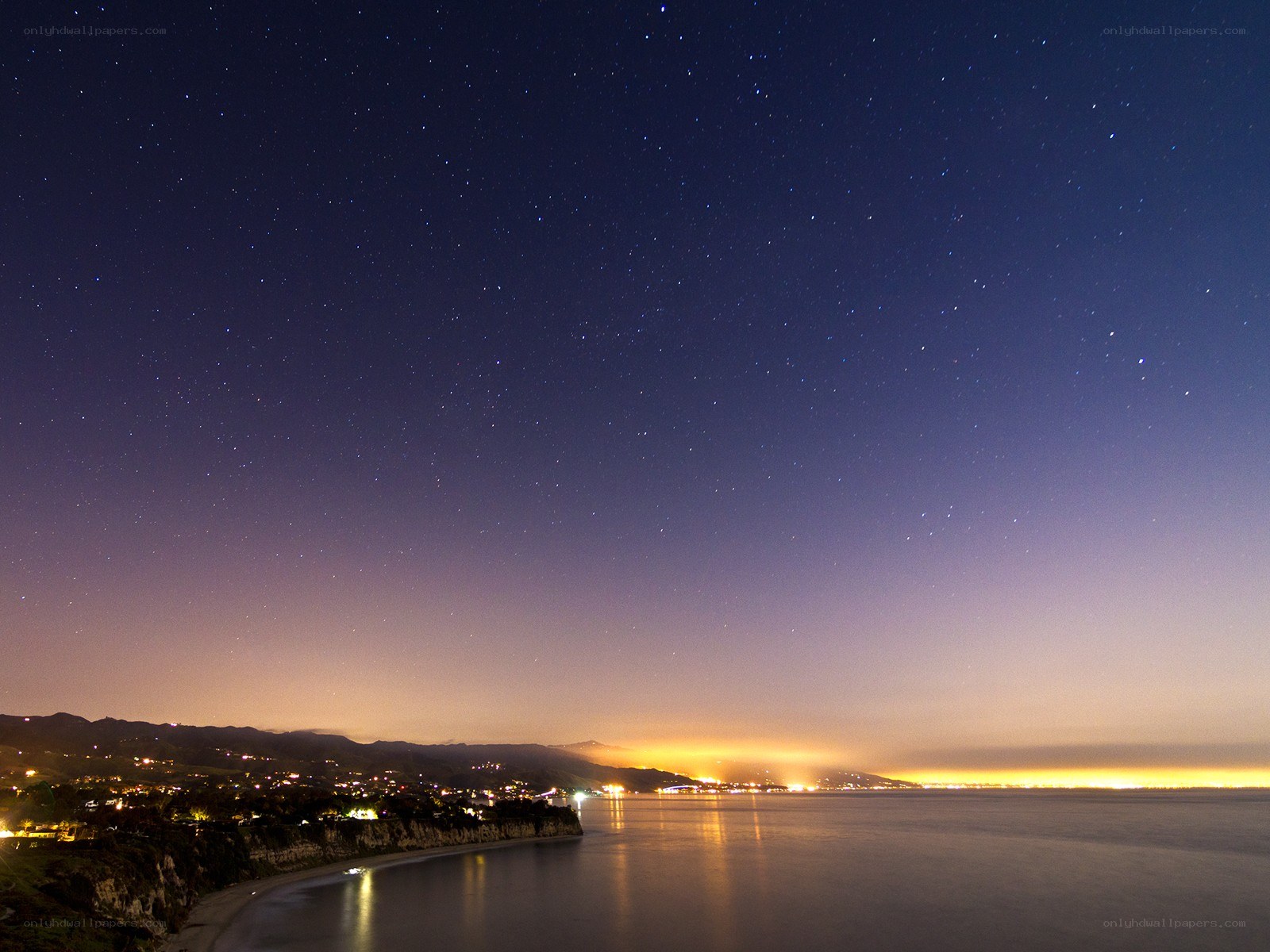 Starry night over coastal town