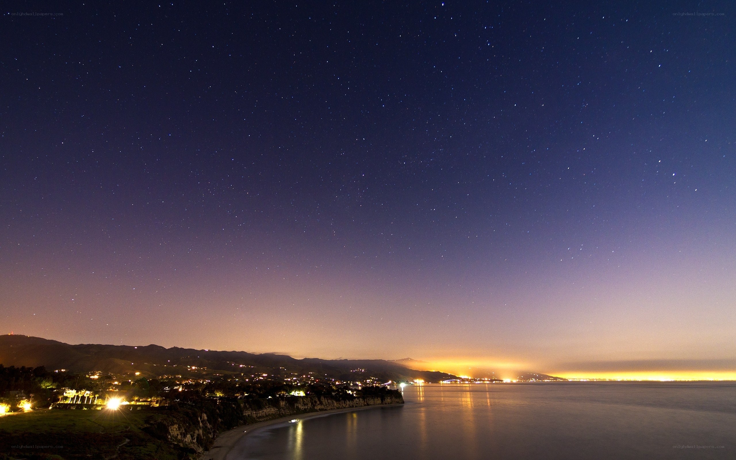 Starry night over coastal town