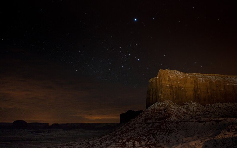 Starry night over desert cliffs