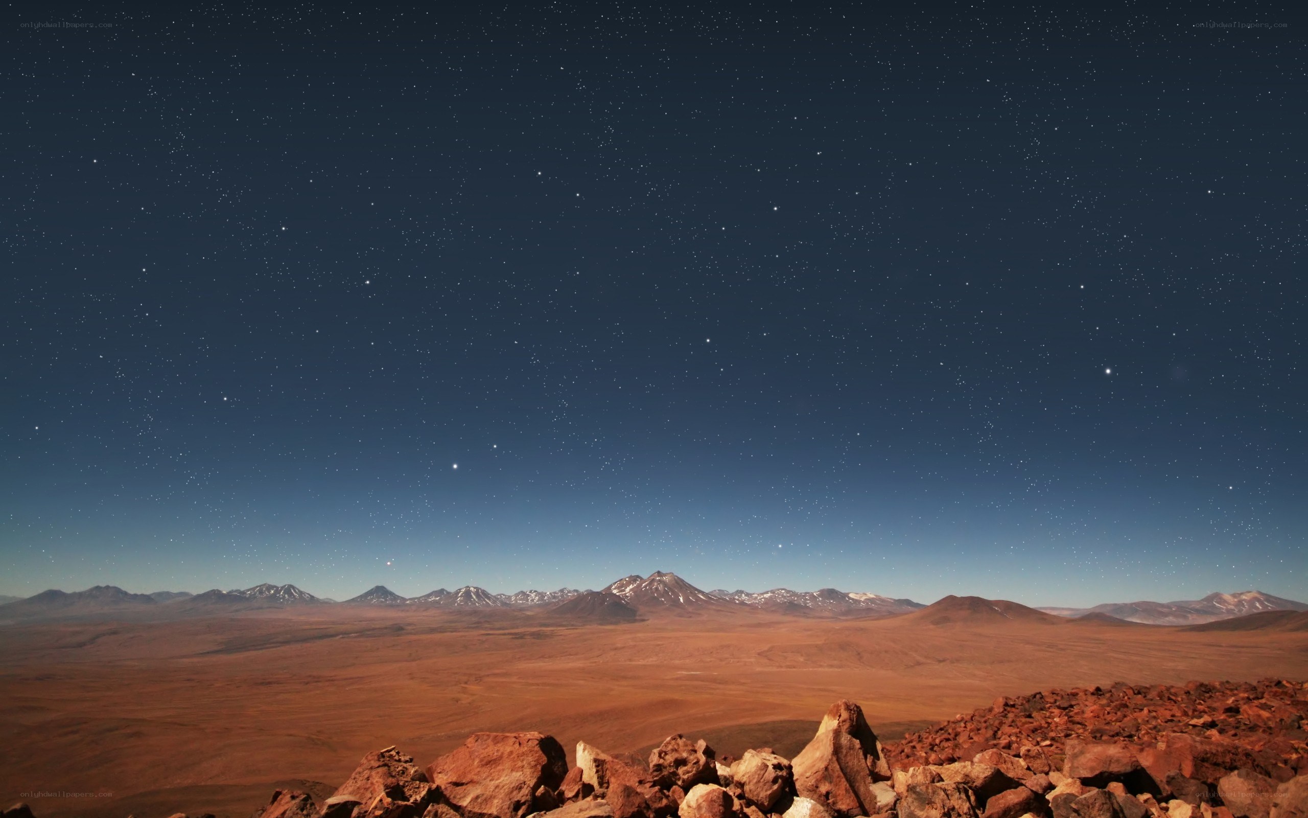 Starry night over desert mountains