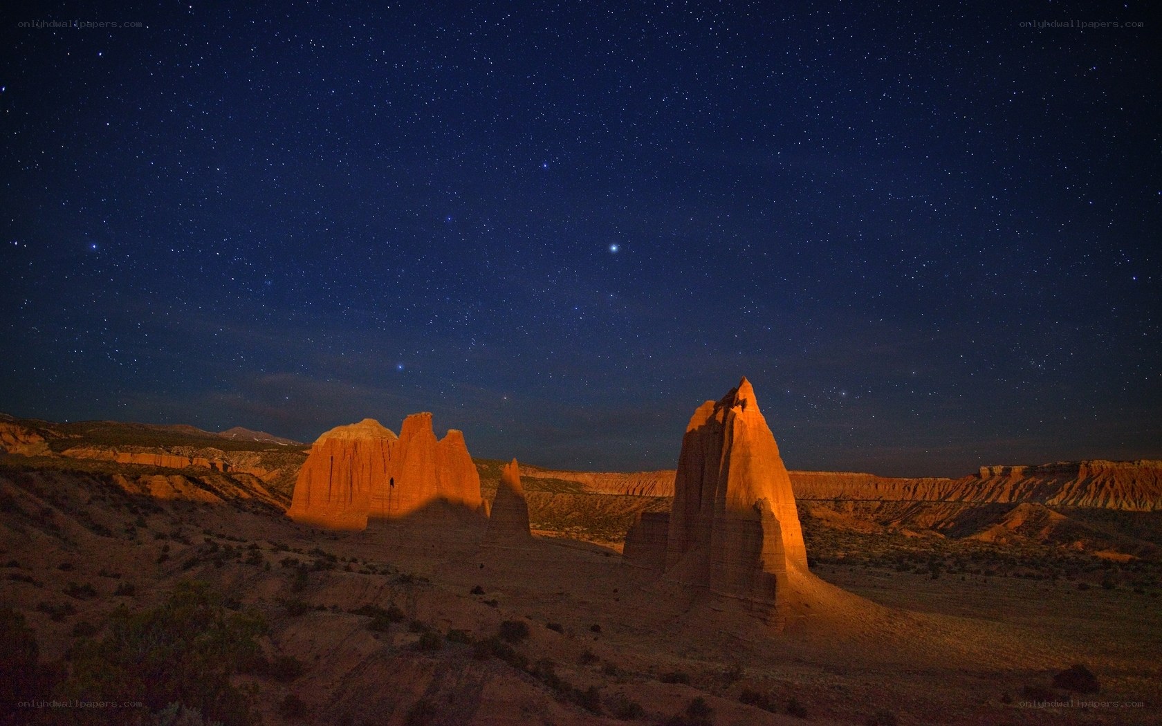 Starry night over desert rock formations