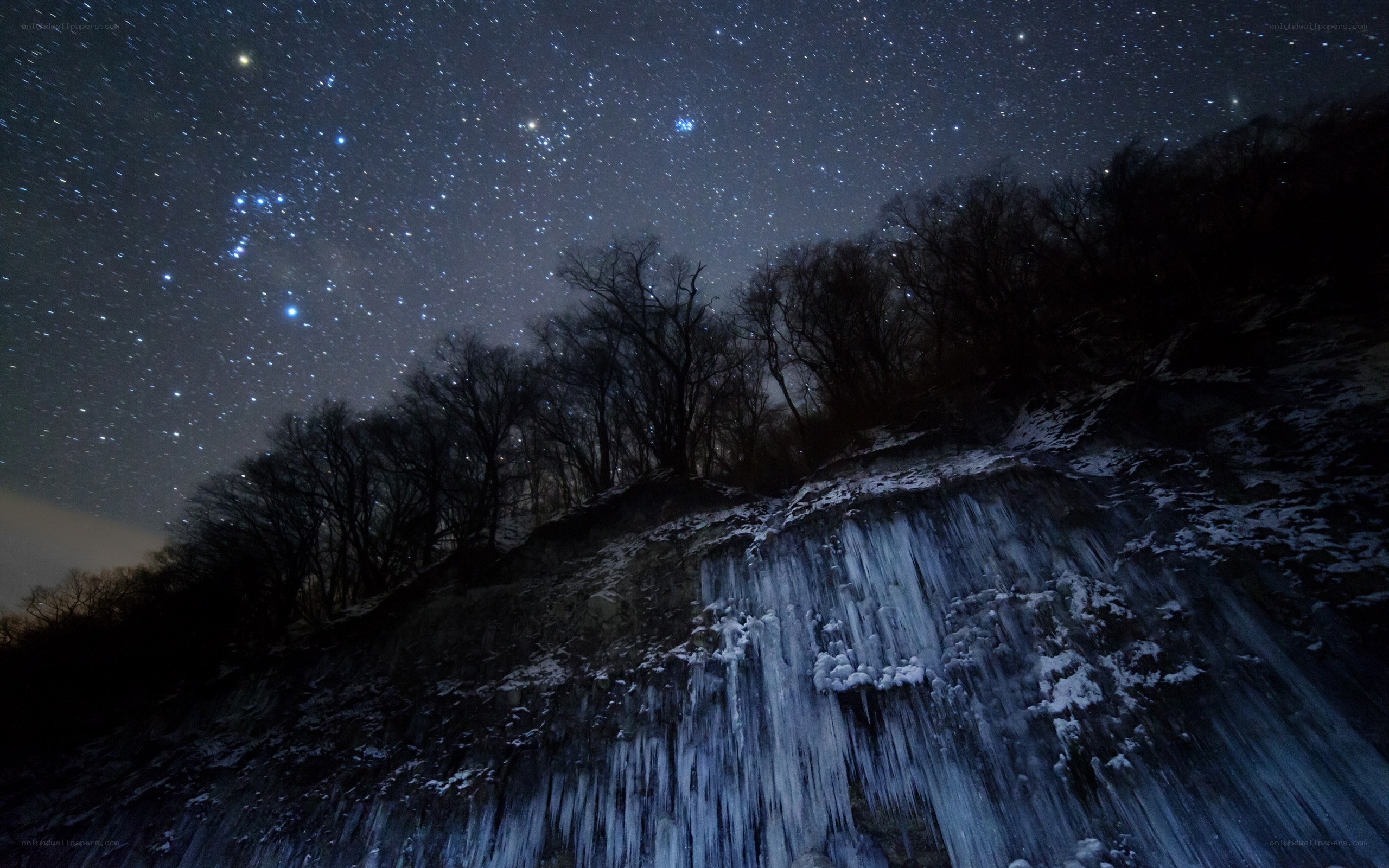 Starry night over icy waterfall