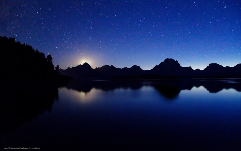 Starry night over mountain lake