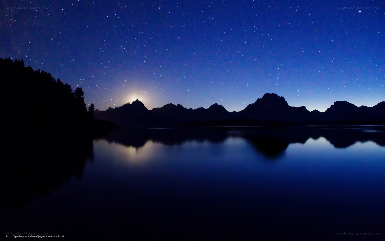 Starry night over mountain lake
