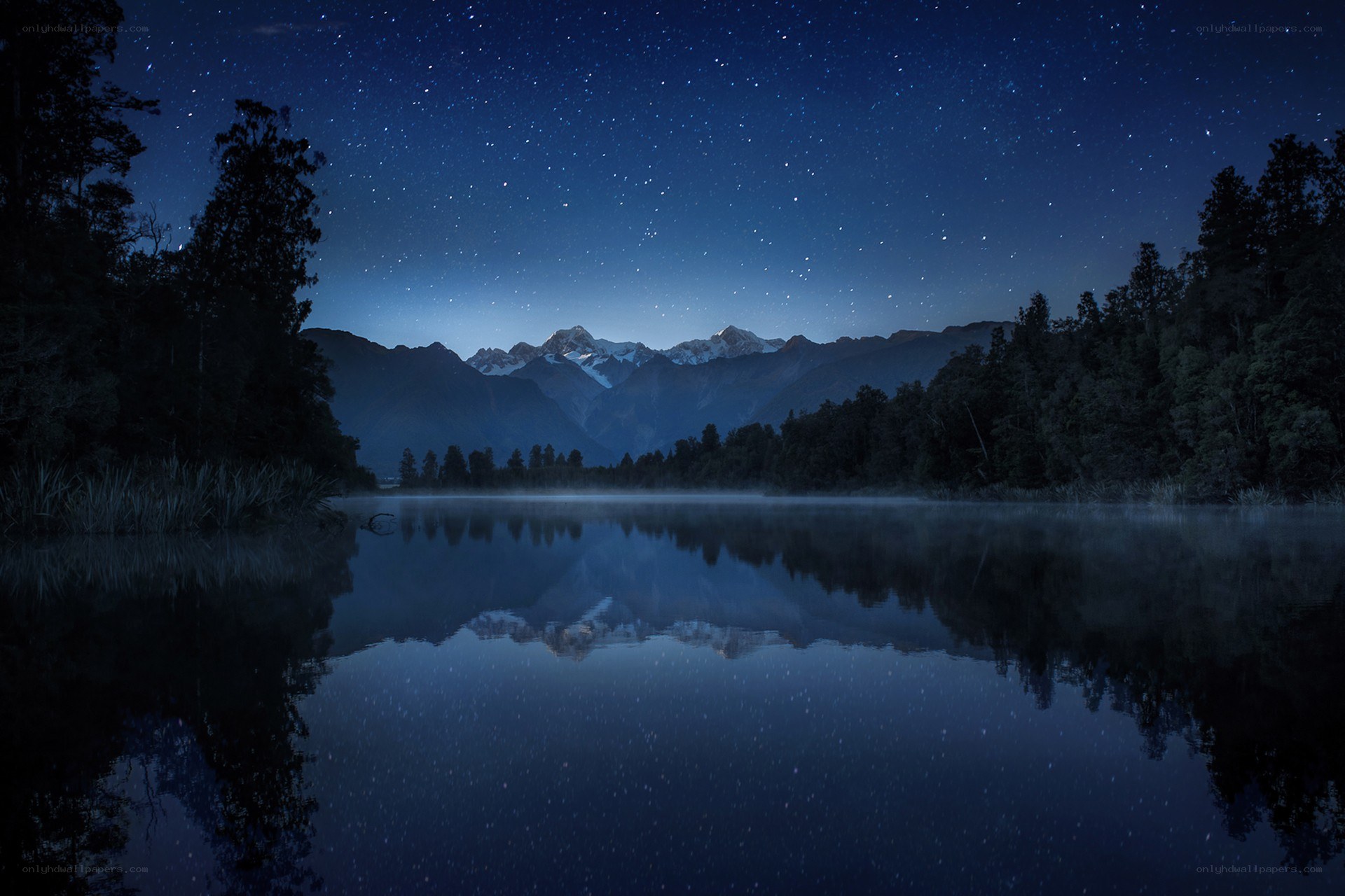 Starry night over mountain lake