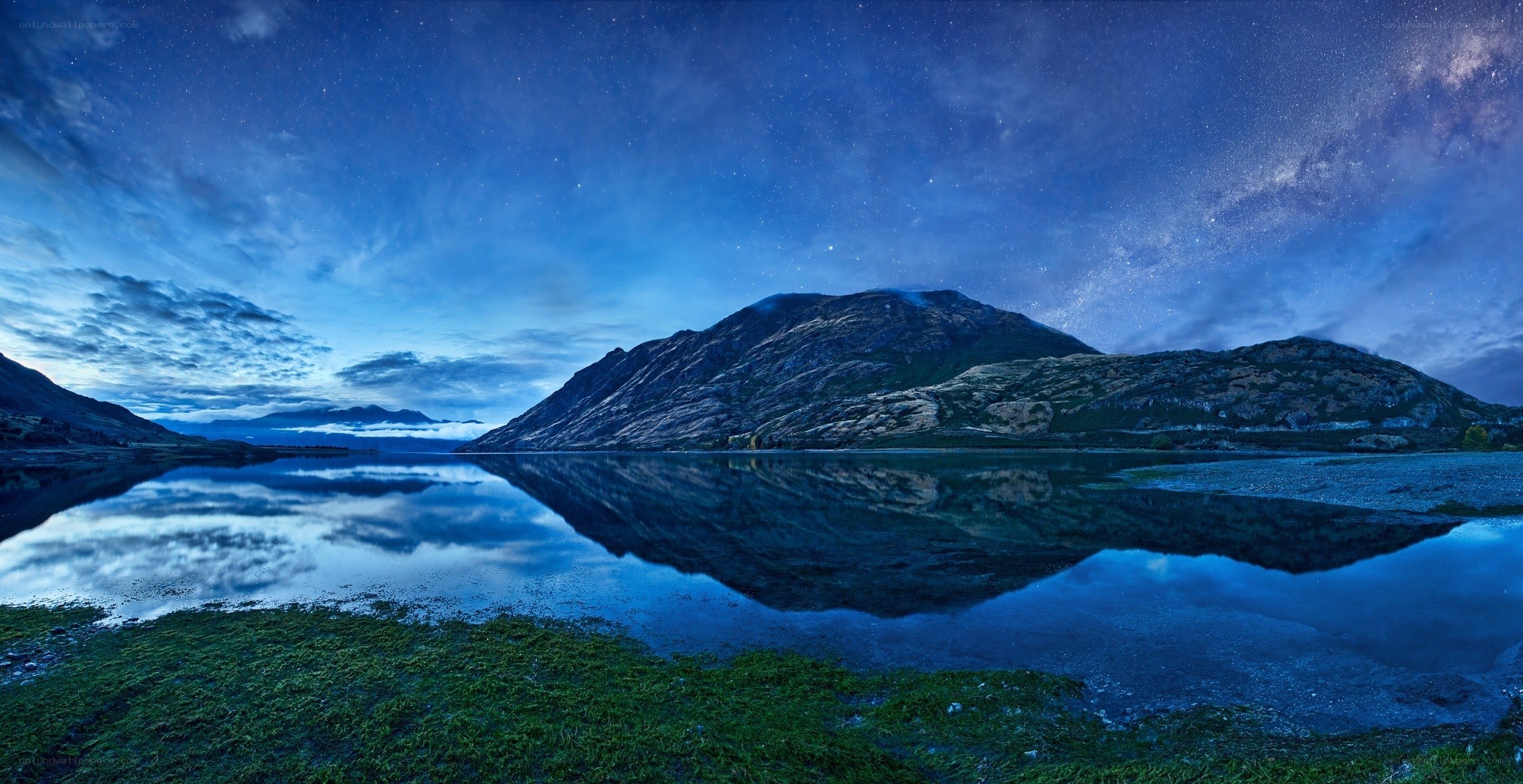 Starry night over mountain lake