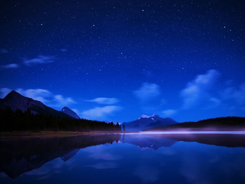Starry night over mountain lake