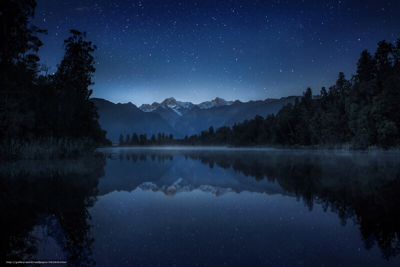 Starry night over mountain lake