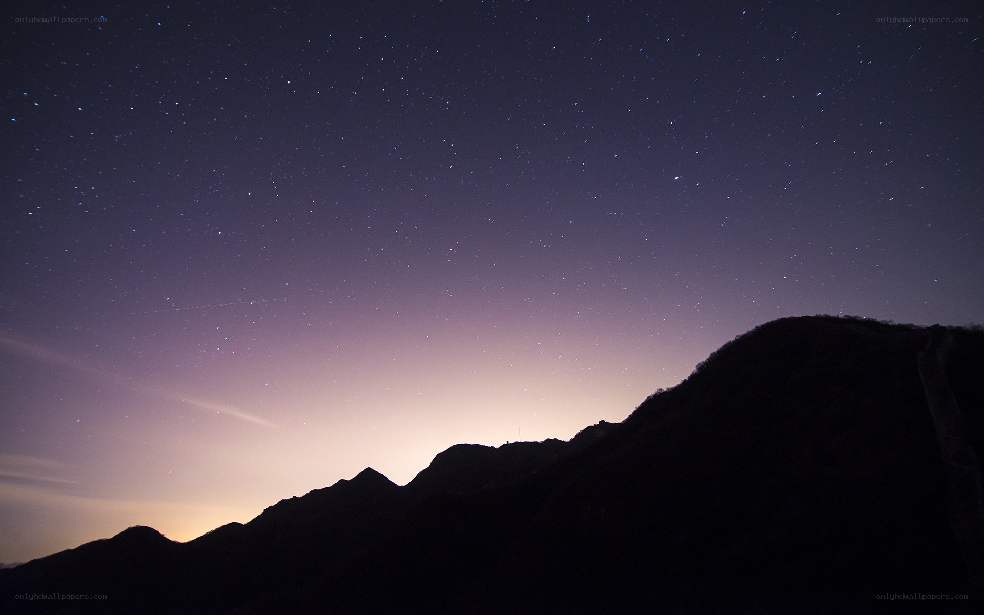 Starry night over mountain silhouette