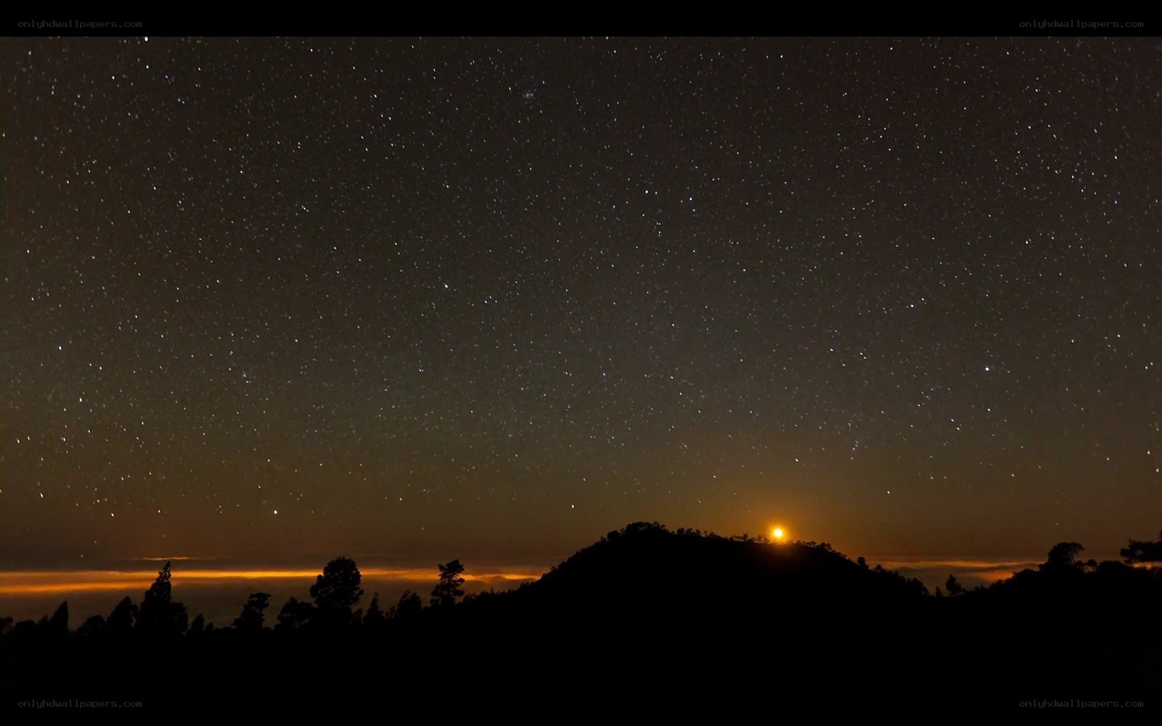 Starry night over mountain silhouette