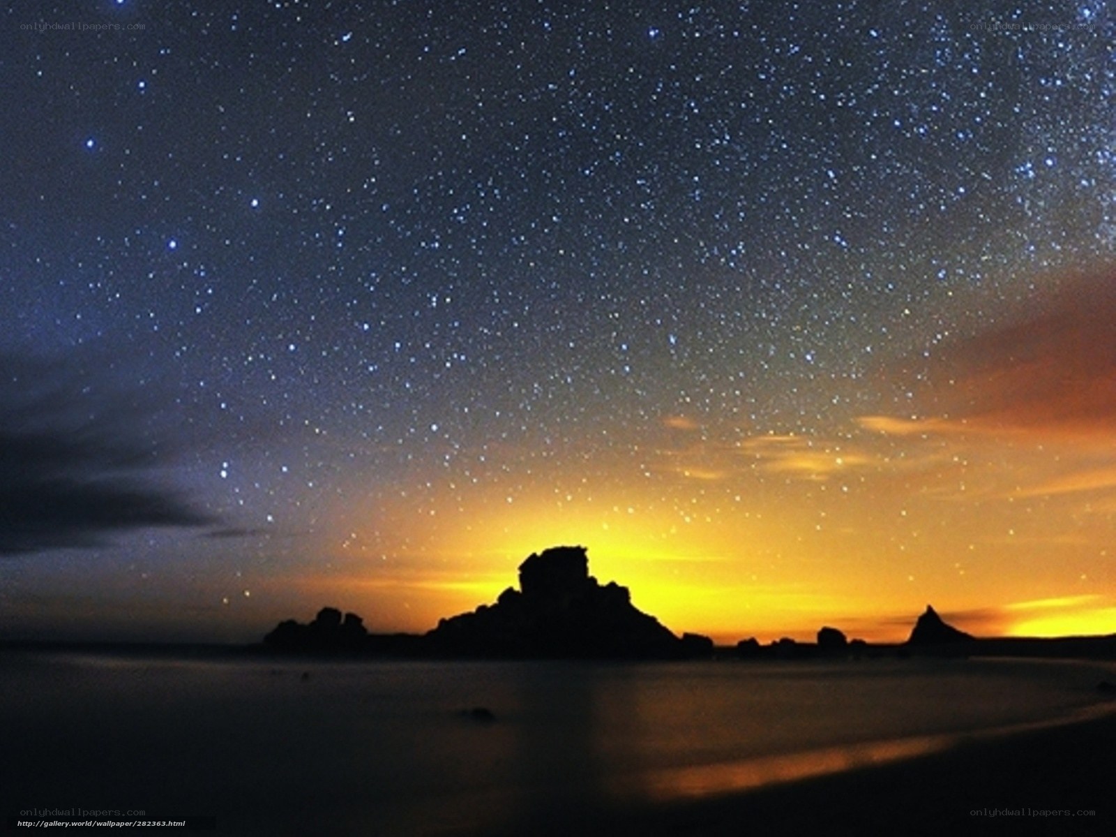 Starry night over rocky coast