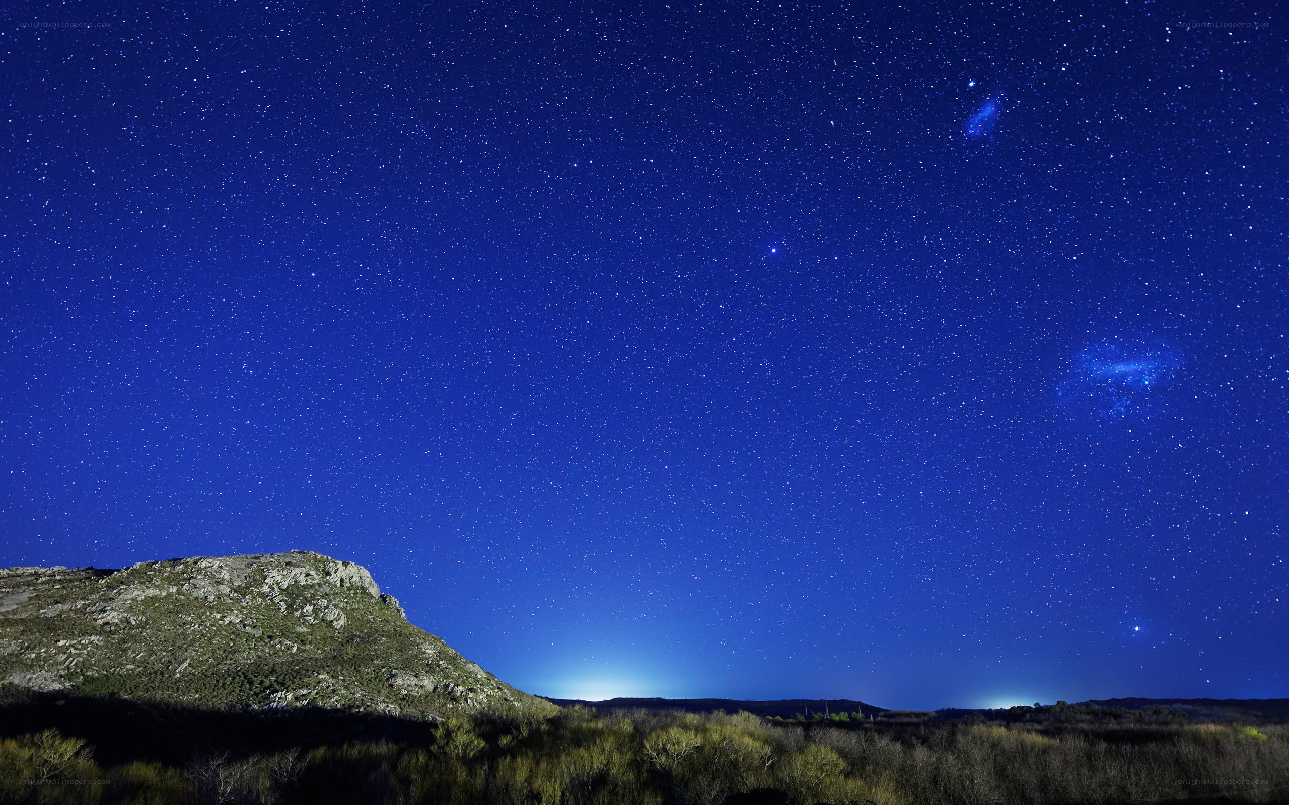 Starry night over rocky hill