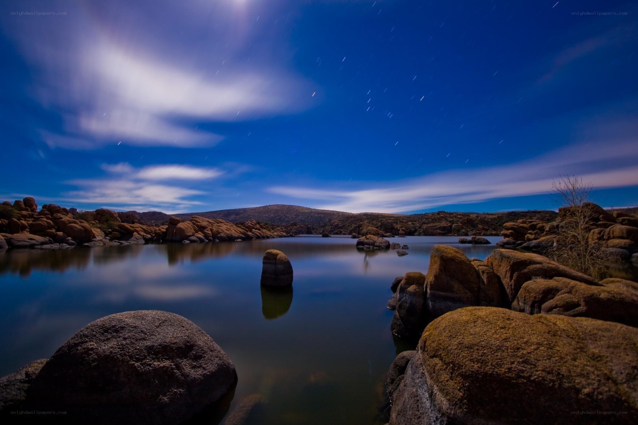 Starry night over rocky lake