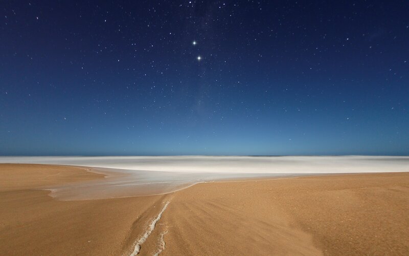 Starry night over sandy beach