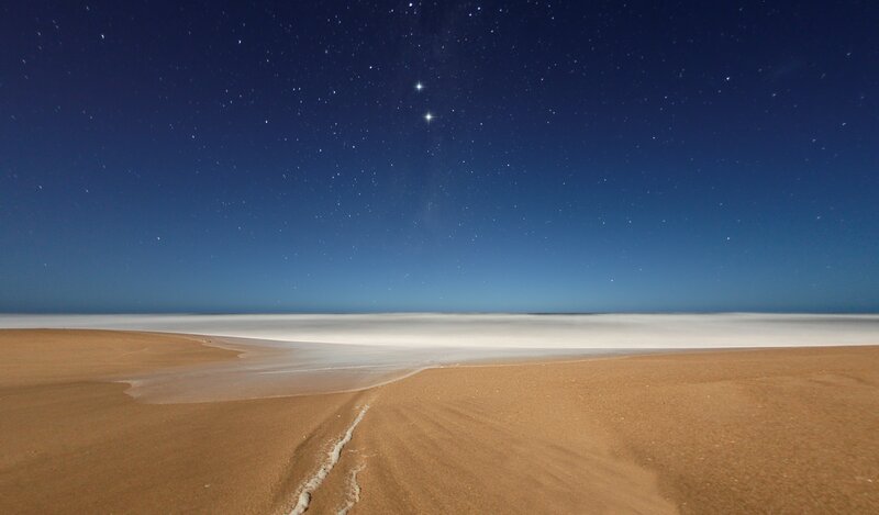 Starry night over sandy beach