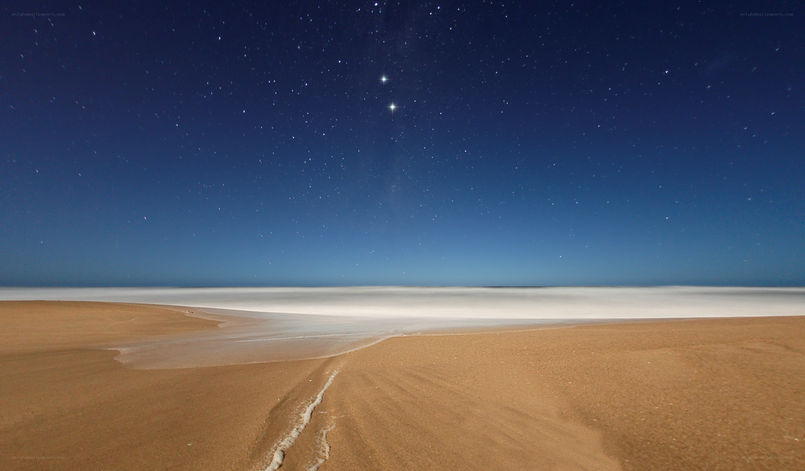 Starry night over sandy beach