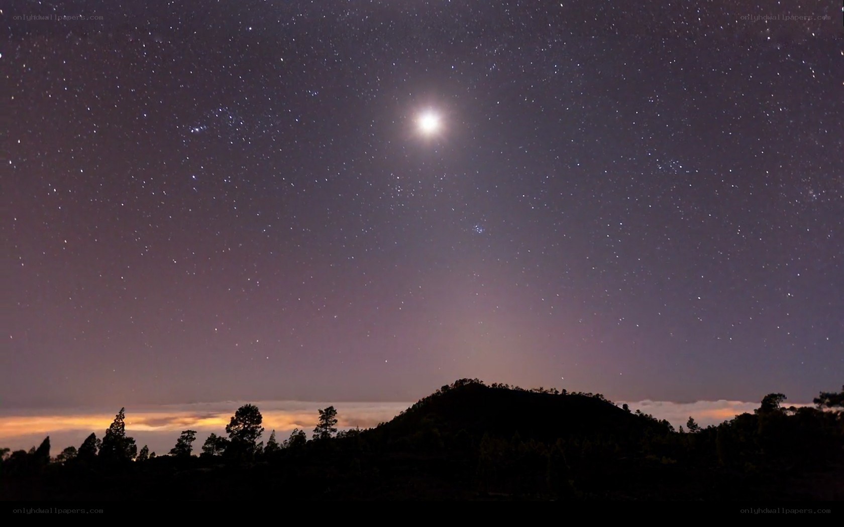 Starry night over silhouetted hills
