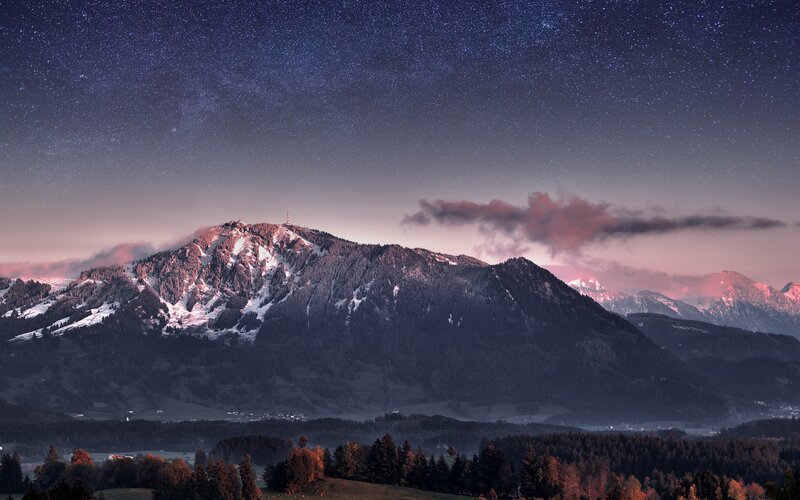 Starry night over snow-capped mountains