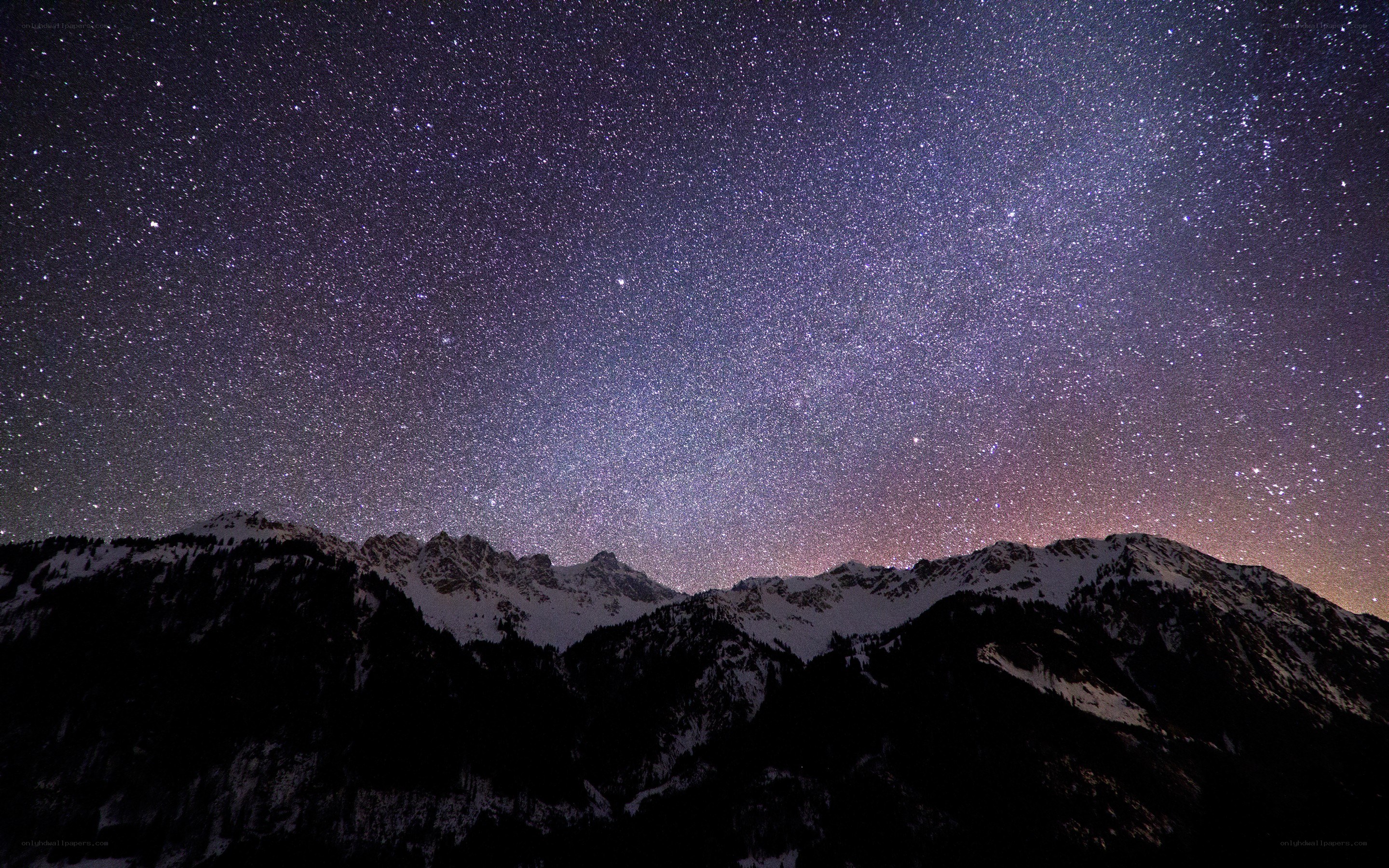 Starry night over snow-capped mountains