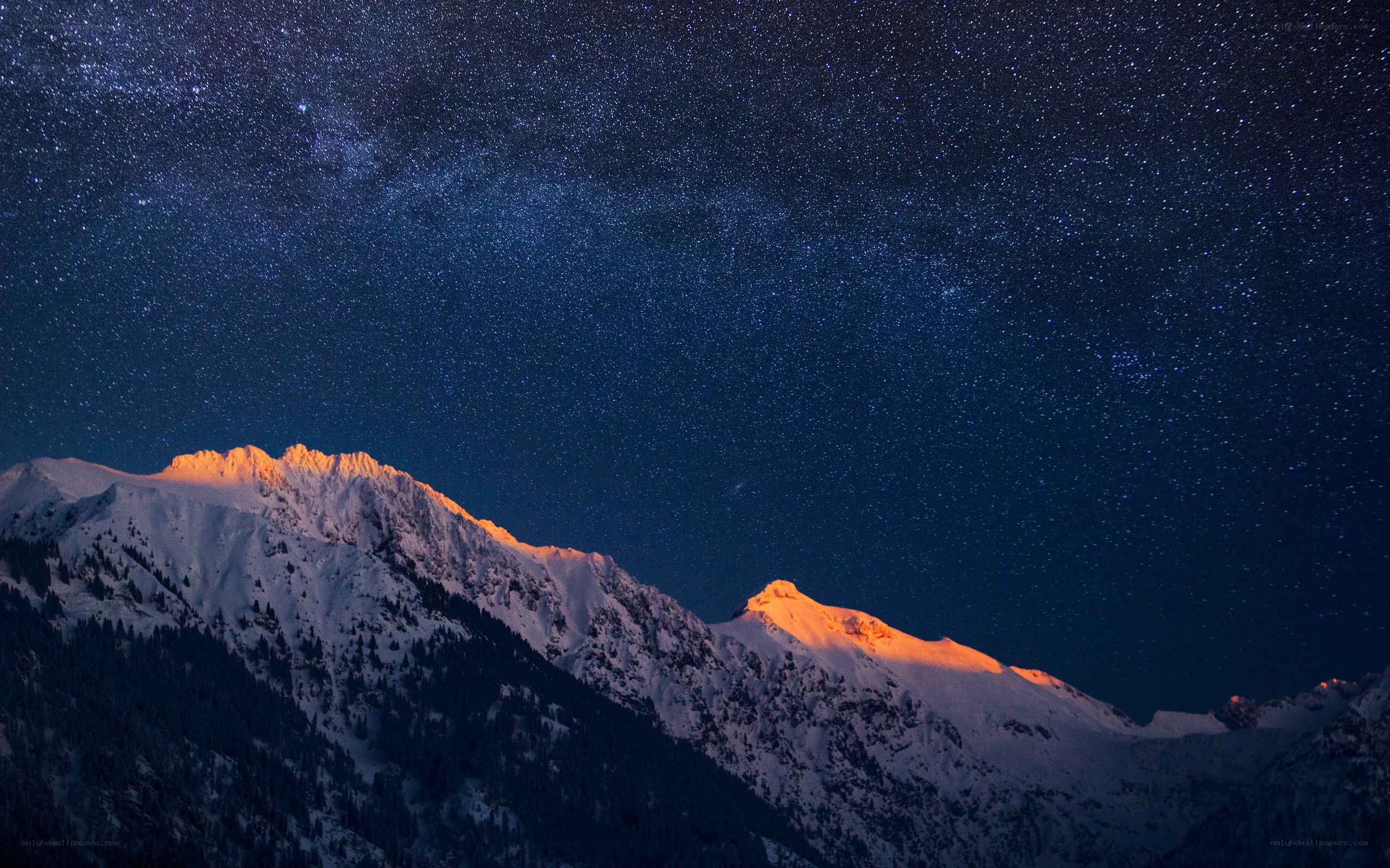 Starry night over snow-capped mountains
