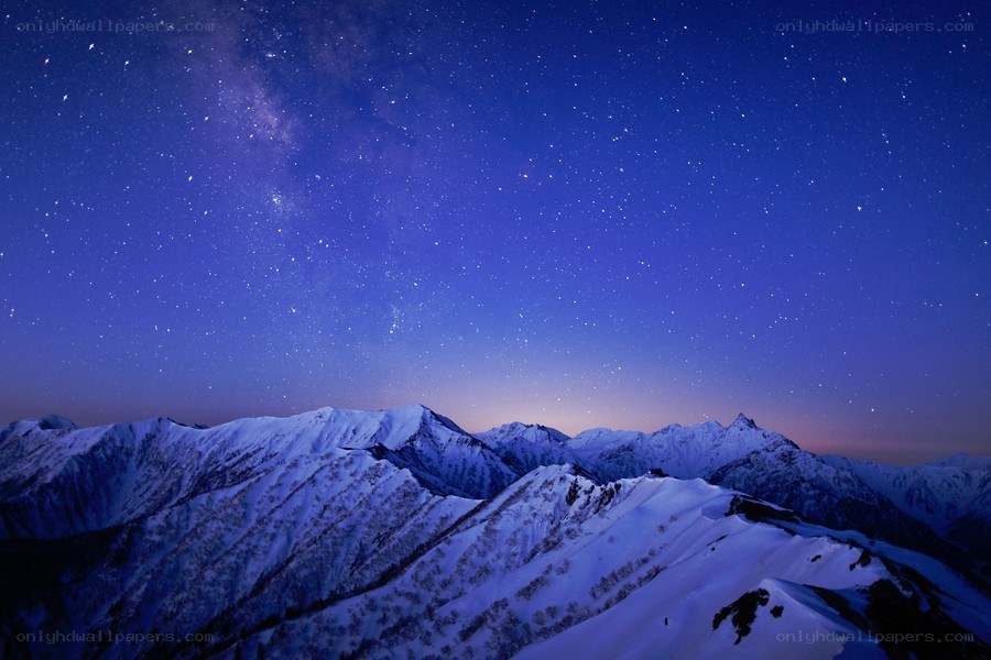 Starry night over snow-capped mountains