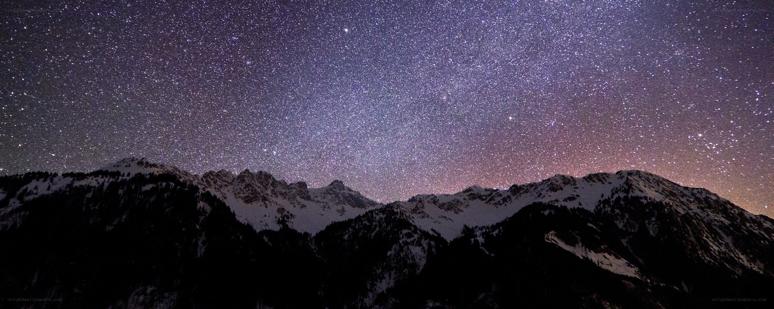 Starry night over snow-capped mountains