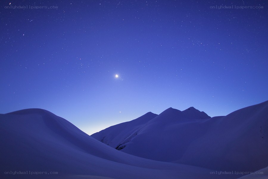 Starry night over snow-covered mountains