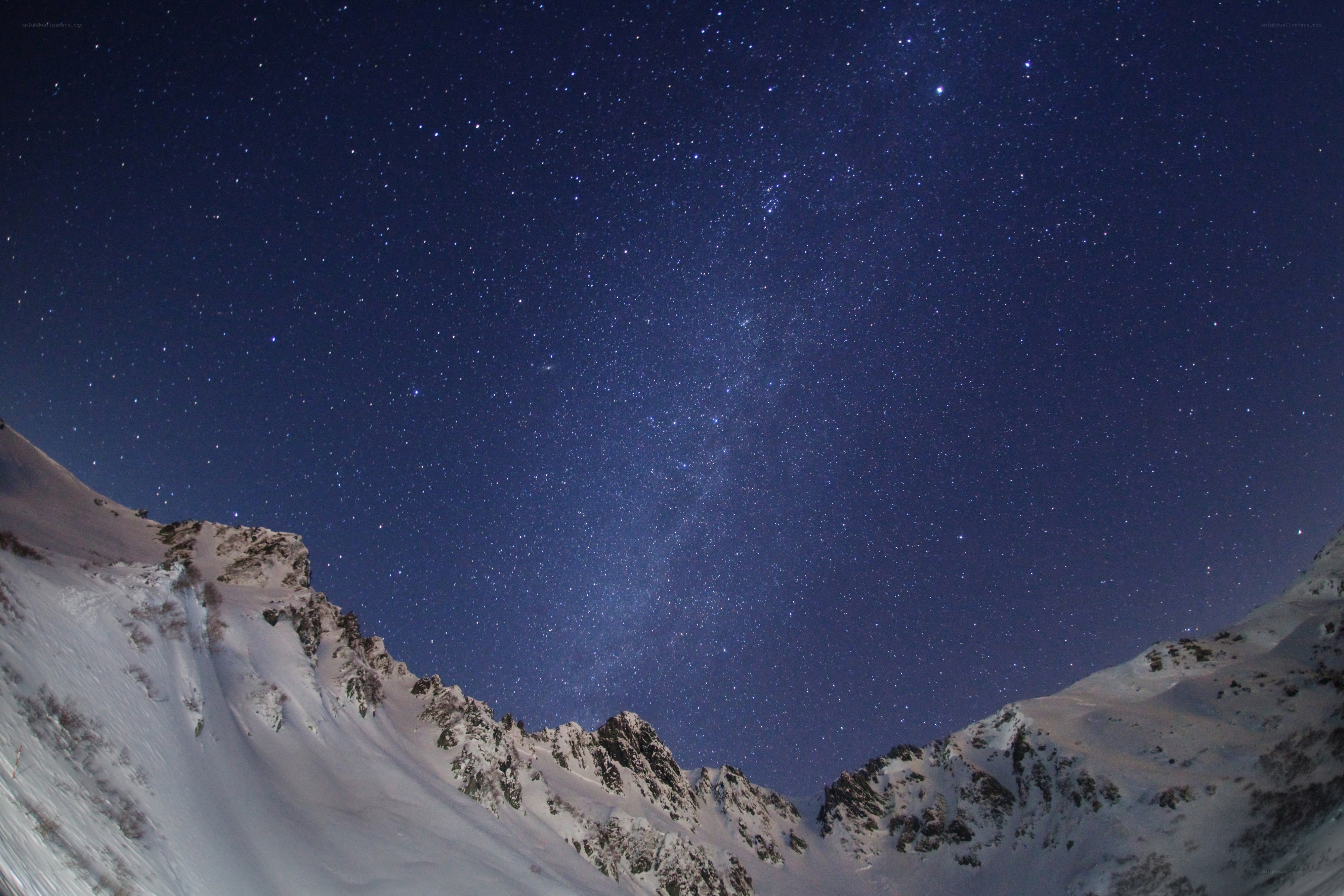 Starry night over snowy mountains