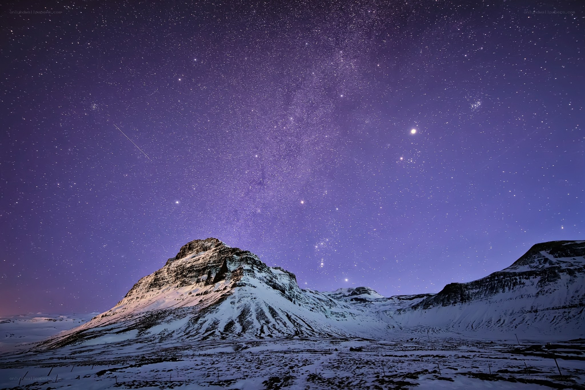 Starry night over snowy mountains