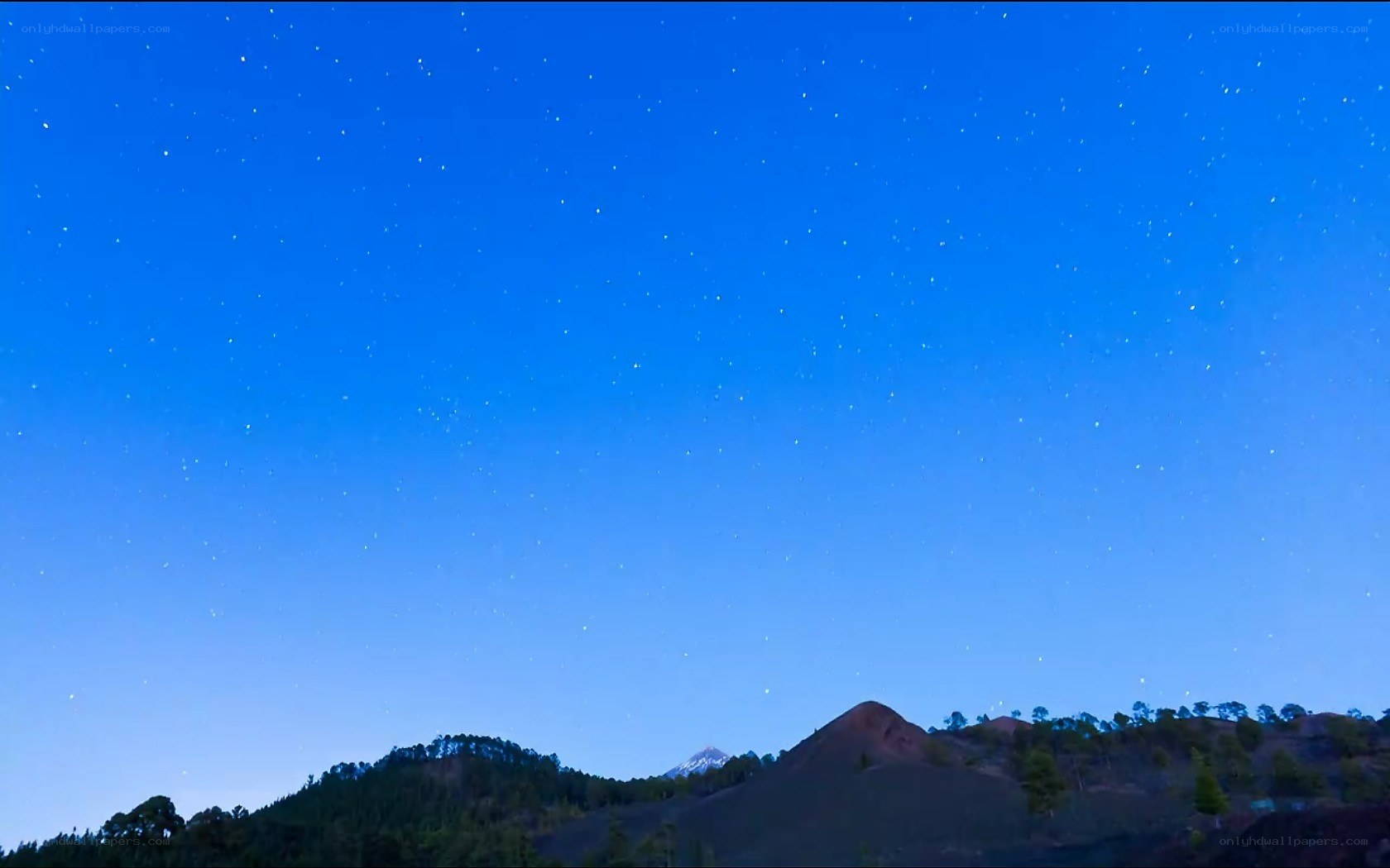 Starry night over volcanic hills