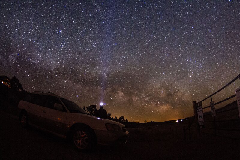 Starry night sky over car