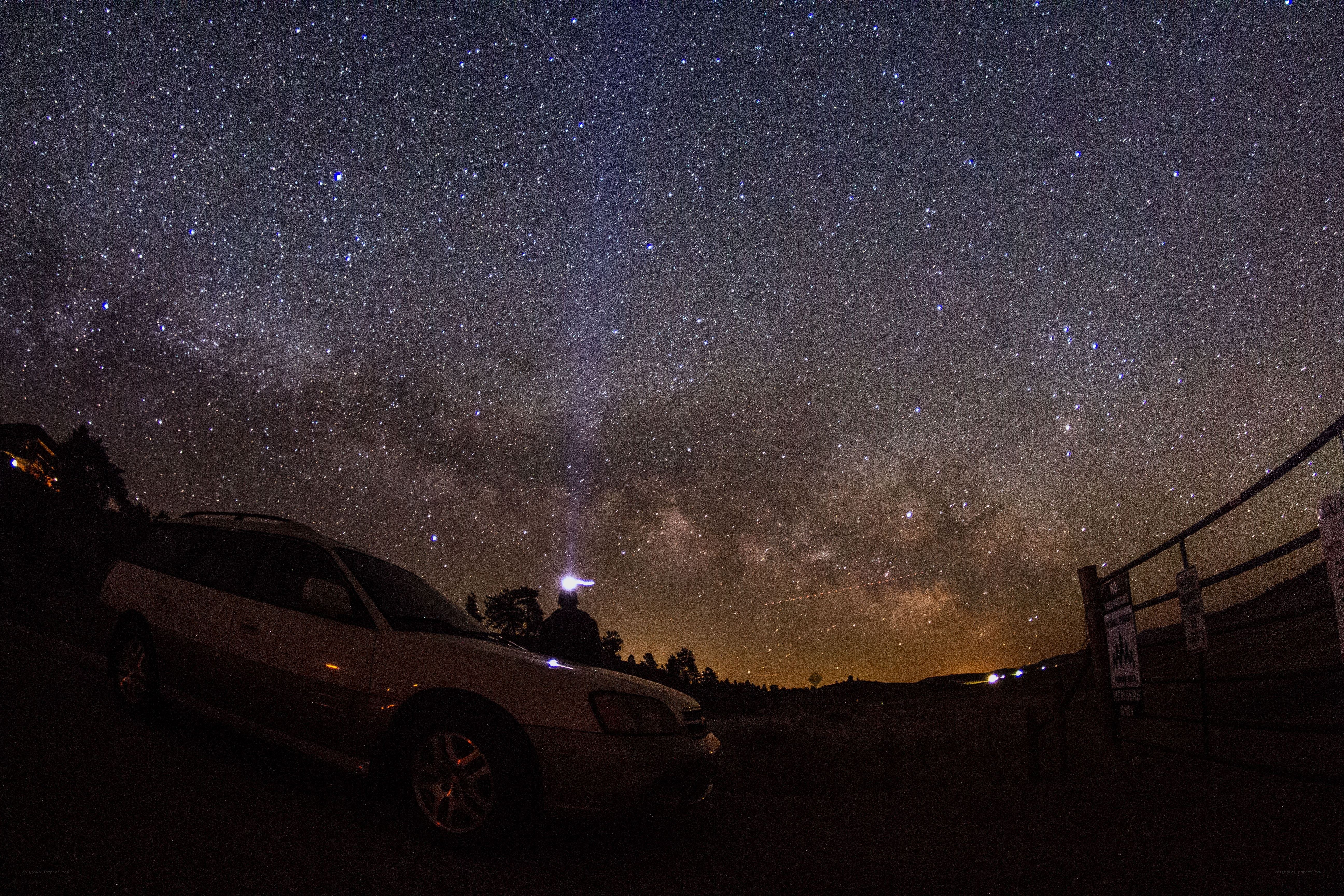 Starry night sky over car