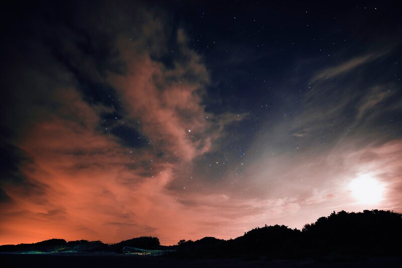 Starry night sky with glowing clouds
