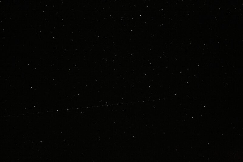 Starry night sky with satellite trail