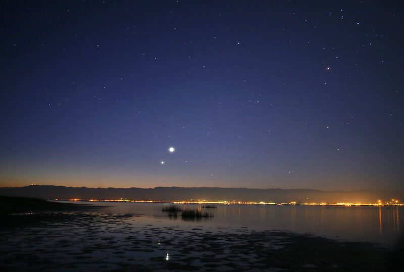 Stars over a coastal city at night