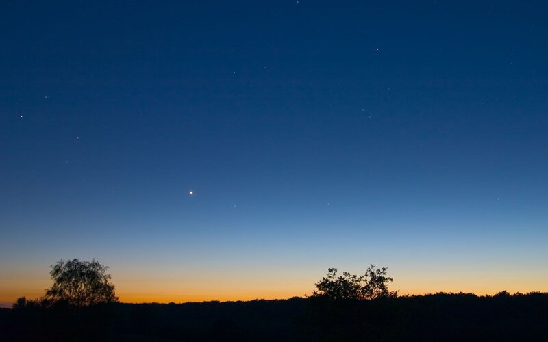 Stars over a silhouetted landscape