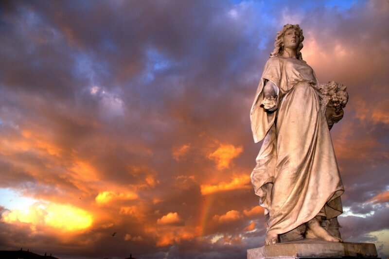 Statue against a sunset sky