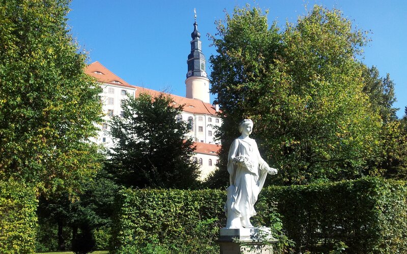 Statue in a garden with castle