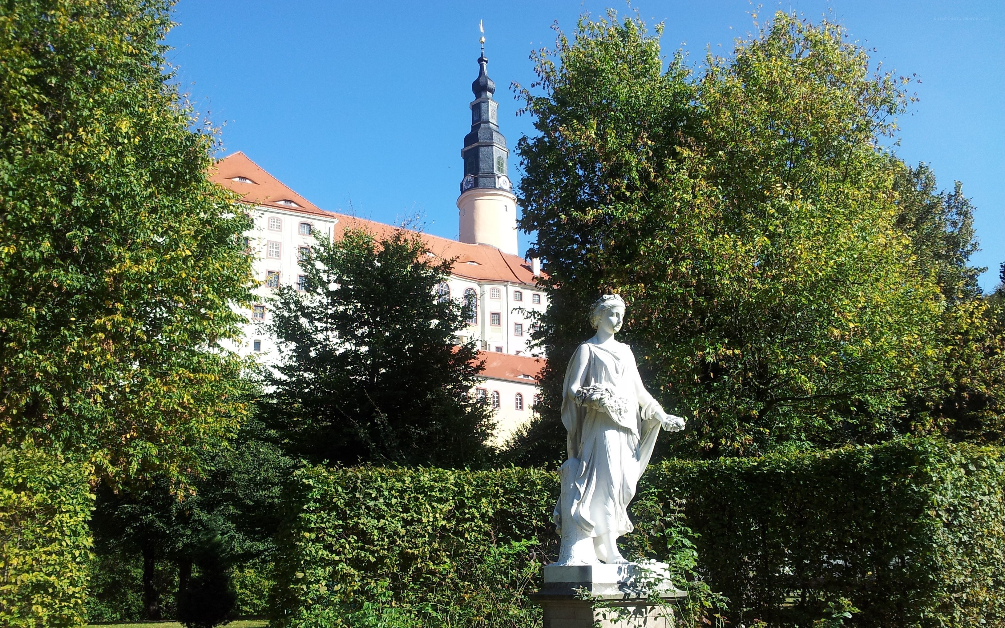 Statue in a garden with castle