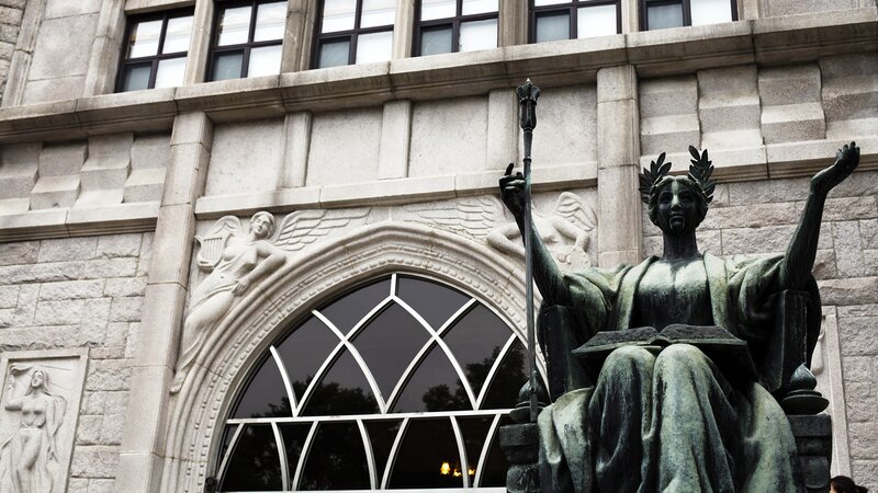 Statue in front of stone building