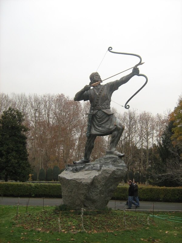 statue of archer on rock