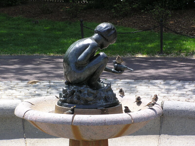 statue of child feeding birds