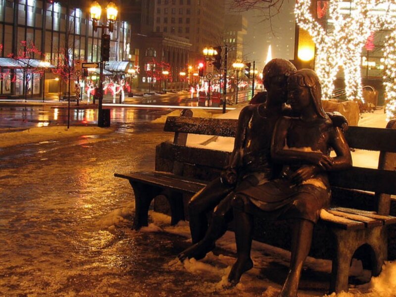 Statue of couple on bench at night