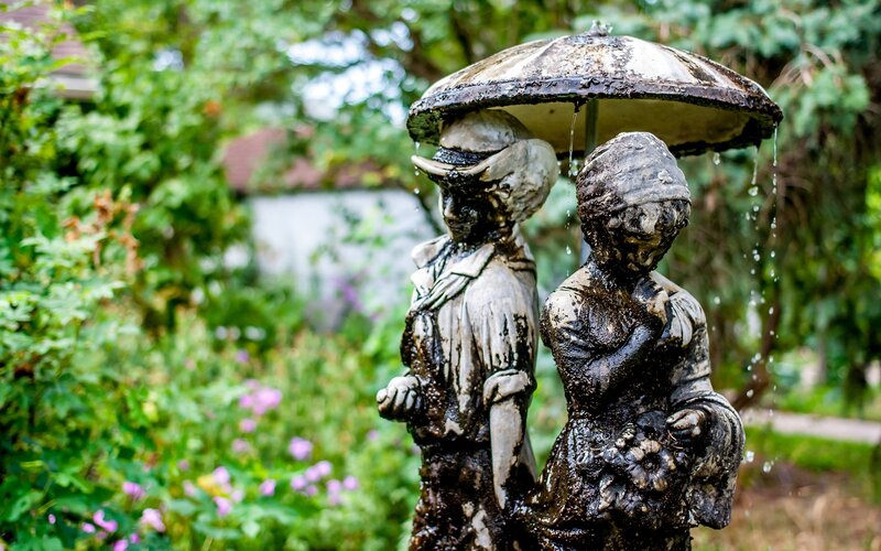 Statue of couple under umbrella