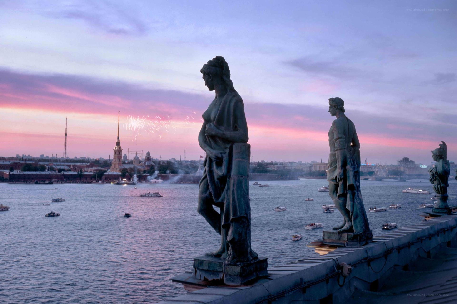 Statues at dusk with fireworks