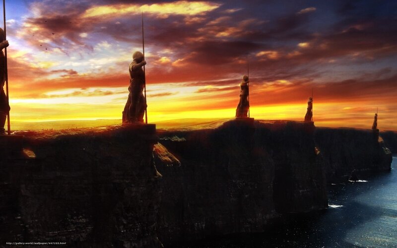statues on a cliff at sunset