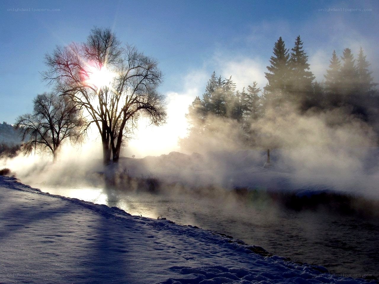 Steam rises over a snowy river